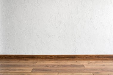 Beyaz duvarı ve parketi olan boş bir oda. En düşük iç tasarım.