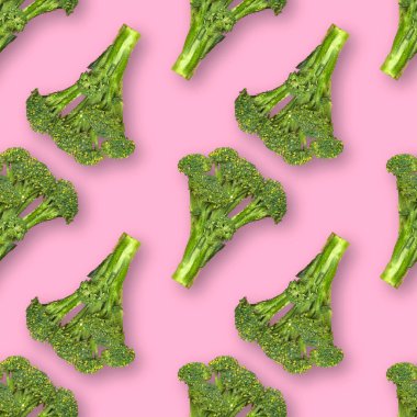 Pembe arka planda izole edilmiş su damlaları ile taze brokoli ile kusursuz desen