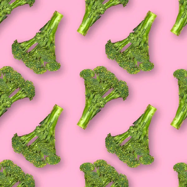 Pembe arka planda izole edilmiş su damlaları ile taze brokoli ile kusursuz desen