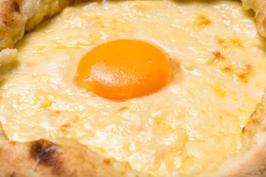 Adjarian Khachapuri yakın plan. Gürcistan ulusal yemeği. Yumurta sarısına odaklan..