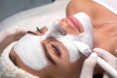 Güzellik salonunda yüzüne maske takmak. Kozmetolog ve gençleştirme ve nemlendirme prosedürü