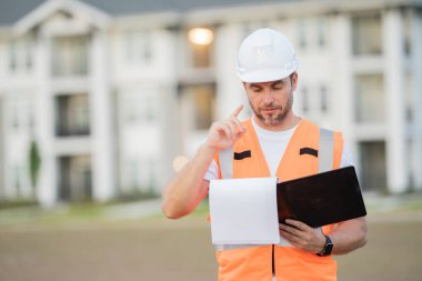 İnşaat işçisi inşaat alanında kahve molası veriyor. Miğferli bir inşaatçı. Şapkalı bir işçi. İnşaat miğferinde portre mekaniği işçisi. Mühendis ustabaşı veya tamirci..