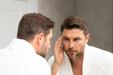 Kozmetik güzellik merkezi. Erkek kozmetik ürünleri. Yüz bakımı cilt bakımı ve güzellik kavramları. Kırışıklıkları olan yakışıklı yaşlı bir adam. Erkek, sağlıklı cilt ve kaplıca. Temiz ciltli son sınıf öğrencisi. Güzel erkek cilt bakımı.