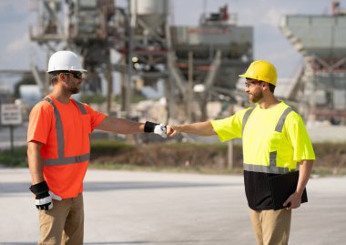 Güvenlik kaskı ve yansıtıcı yelek giymiş iki erkek mühendis rafineri alanında belgeleri tartışıyor. Petrol ve gaz endüstrisi, enerji üretimi, petrol üretimi, akaryakıt ekonomisi ağır sanayi operasyonları