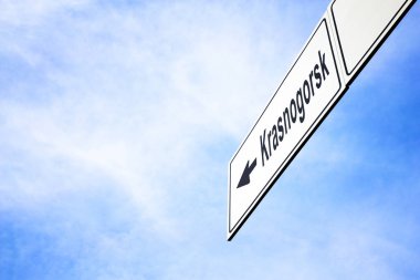 Bir ok işaret ile beyaz tabela Krasnogorsk, Moskova Oblast, Rusya, doğru seyahat, gezinti ve yön kavramı puslu bir mavi gökyüzünde karşı yaptı. Yola