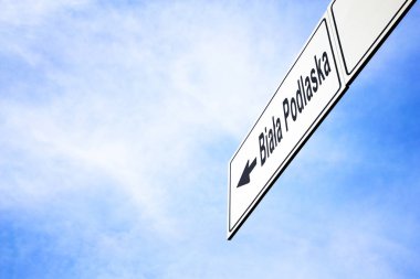 Bir ok işaret ile beyaz tabela doğru Biala Podlaska, Polonya, seyahat, gezinti ve yön kavramı puslu bir mavi gökyüzünde karşı yaptı. Tabela için yola