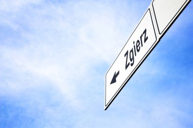 Bir ok işaret ile beyaz tabela doğru Zgıerz, Polonya, seyahat, gezinti ve yön kavramı puslu bir mavi gökyüzünde karşı yaptı. Tabela için yola