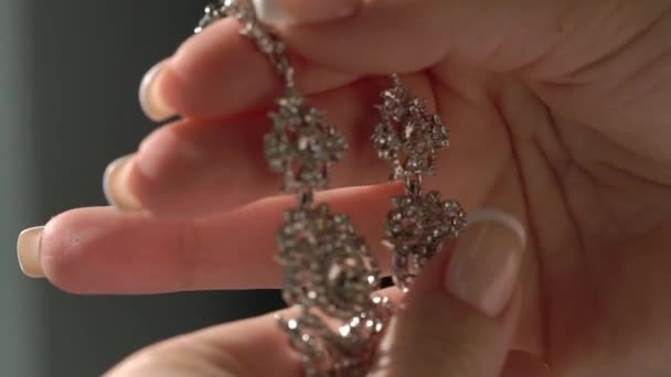 Woman holding and touching earrings — Stock Video