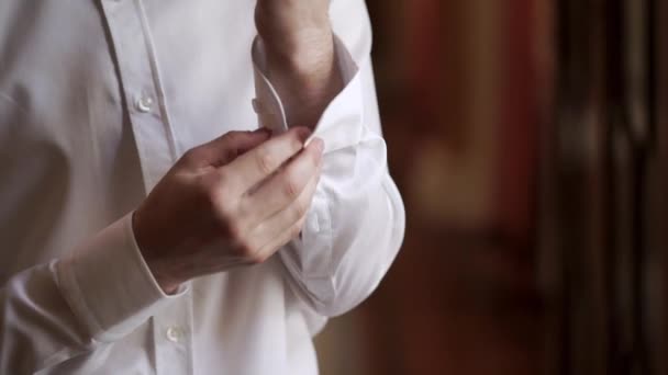 Hombre joven abotonando camisa blanca — Vídeos de Stock