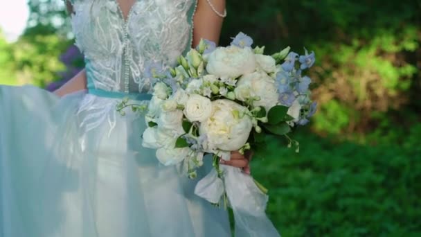 Bride with bouquet walking in a park — Stock Video
