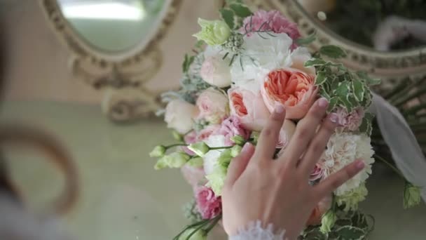 Молодая невеста трогает свадебный букет — стоковое видео