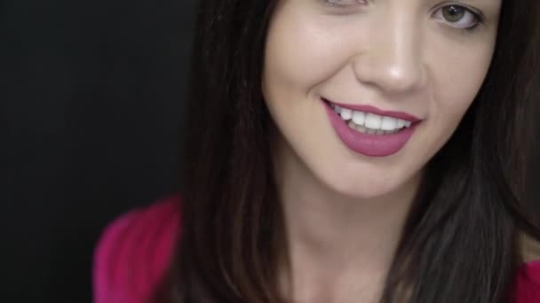 Mujer joven sonriendo al fondo negro — Vídeos de Stock