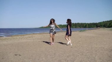Çalışan ve elbiseler sahilde dans iki genç kadın