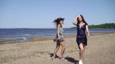Çalışan ve elbiseler sahilde dans iki genç kadın
