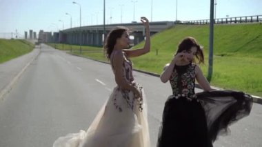 İki genç kadın bir yolda poz