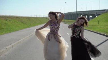 İki genç kadın bir yolda poz