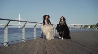 Çalışan ve elbiseler sallayarak iki genç kadın