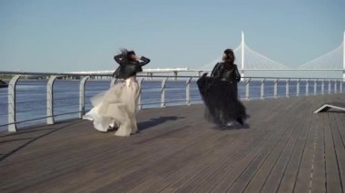 Çalışan ve elbiseler sallayarak iki genç kadın