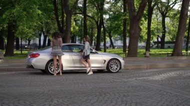 İki genç kadın lüks spor otomobil poz