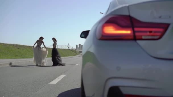 Kaksi nuorta naista poseeraa tiellä. — kuvapankkivideo