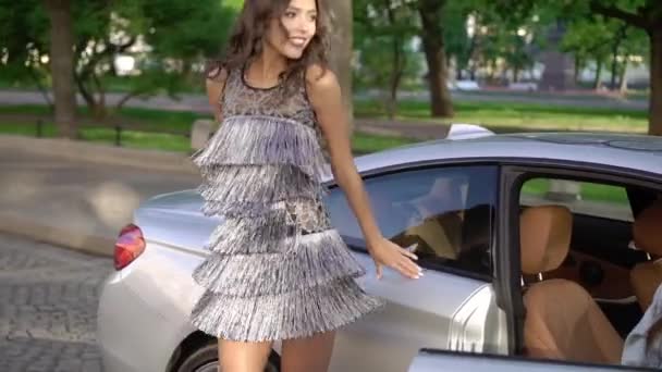 Dos mujeres jóvenes posando cerca de coches deportivos de lujo — Vídeo de stock
