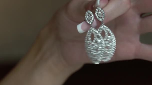 Woman holding earrings in hand — Stock Video