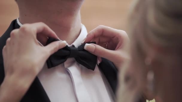 Young woman fixing bow tie for man — Stock Video