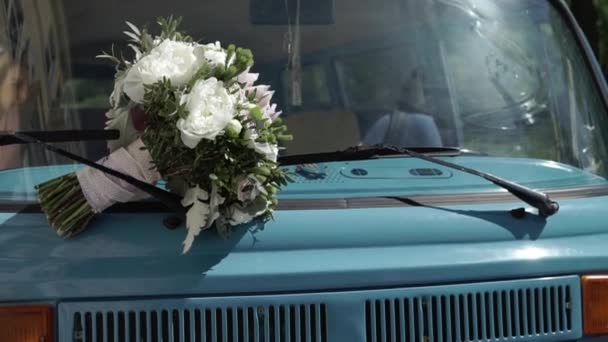 Buquê de noiva em um capuz de ônibus retro azul — Vídeo de Stock