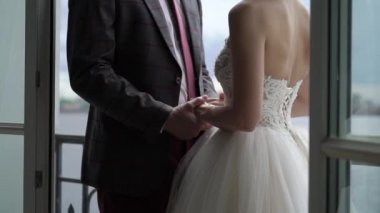 Gelin ve damat el ele tutuşuyorlar.