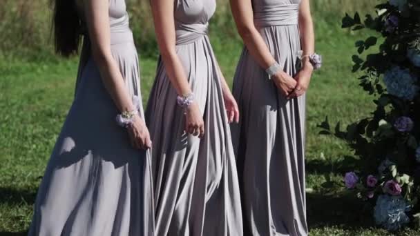 Damas de honor en vestidos grises azules que se quedan en la ceremonia de boda al aire libre — Vídeo de stock