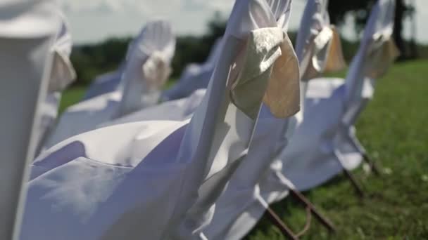 Bílá židle na oslavu svatební obřad venku v létě větrný den — Stock video