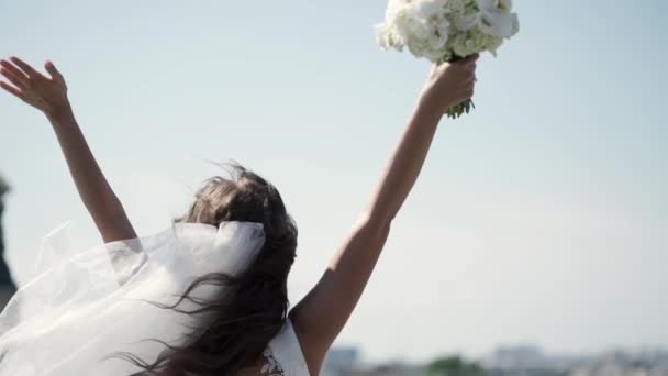 A virágok csokor az ablakban fogását egy tetőtéri kezeket fel tartózkodó fiatal menyasszony