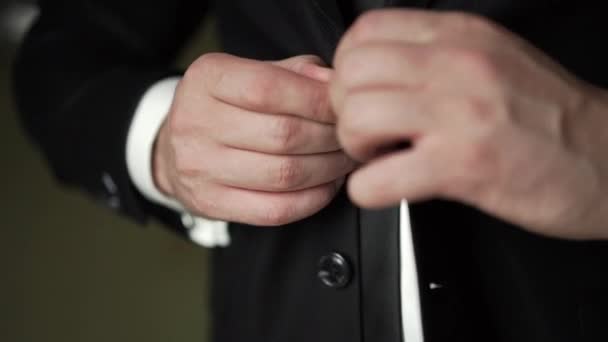 Junger Mann zieht klassische schwarze Jacke an — Stockvideo
