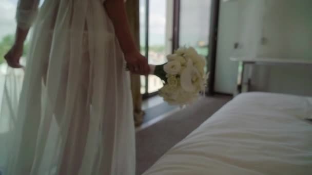 白い花の花束とランジェリーの寝室に歩いている若い強い美しい女性 — ストック動画
