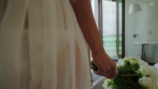Молодая сильная красивая женщина гуляет в спальне в нижнем белье с букетом с белыми цветами — стоковое видео