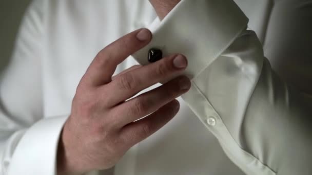 Young man in white shirt put on cuff links — Stock Video