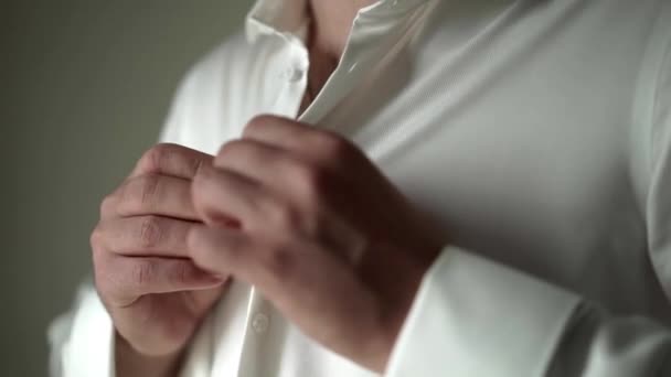 Hombre joven abotonando camisa blanca — Vídeo de stock