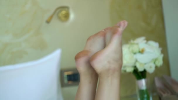 Jeune femme forte se couche sur le lit avec bouquet nuptial avec des roses blanches — Video