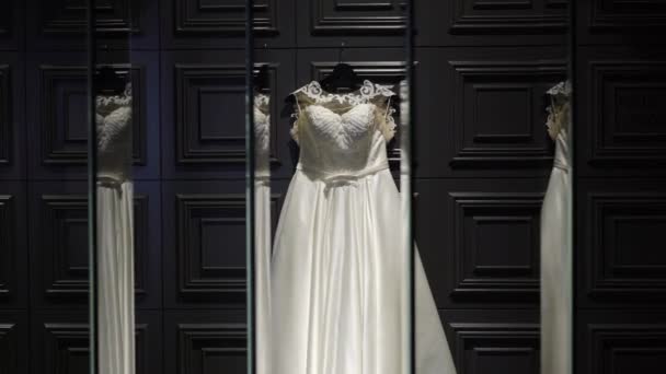 白色婚纱婚纱礼服在黑暗的墙壁与反射在镜子里 — 图库视频影像