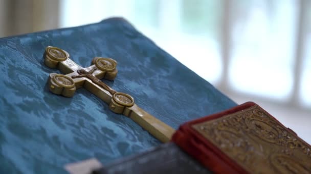 Libros y cruz de oro en la iglesia — Vídeo de stock