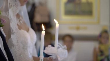 Gelin ve damat töreninde kilisede mum tutan