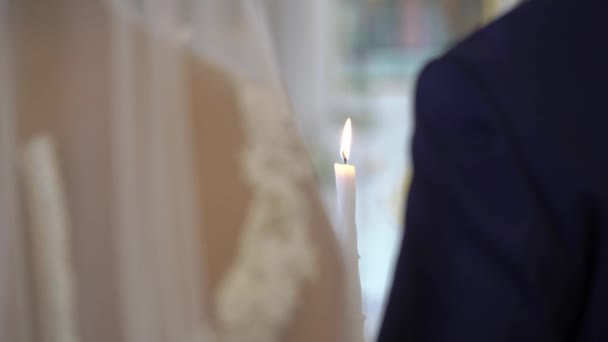 Novia y novio sosteniendo velas en la iglesia en la ceremonia — Vídeos de Stock