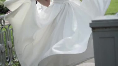 Beyaz gelin elbisesini sallayarak Genç gelin çembere öncesinde damat park ağır çekimde