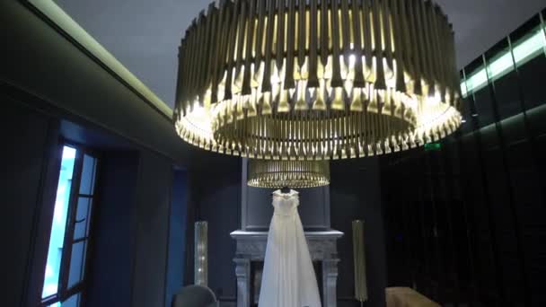 Біла весільна сукня біля каміна в інтер'єрі розкішного готелю — стокове відео