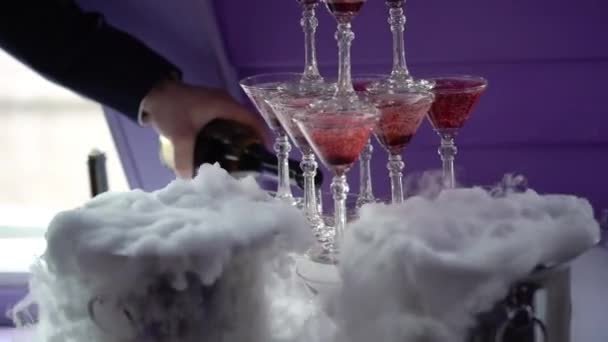 Люди поливають вино до піраміди келихів шампанським — стокове відео