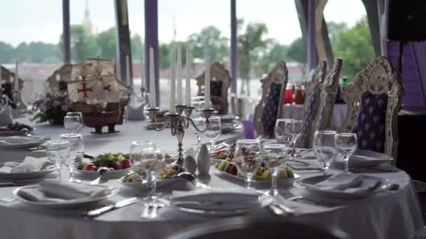 Placa, guardanapo de pano, faca e garfo em pano branco na mesa no restaurante — Vídeo de Stock