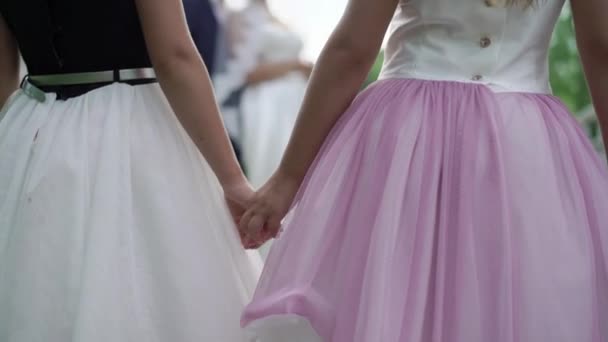 Two small chlidren girls holding hands looking at bride and groom embracing lovely couple embracing on background unrecognizable — Stock Video