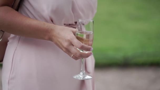Γυναίκα σε ροζ φόρεμα με ποτήρι αφρώδους οίνου στο κόμμα — Αρχείο Βίντεο