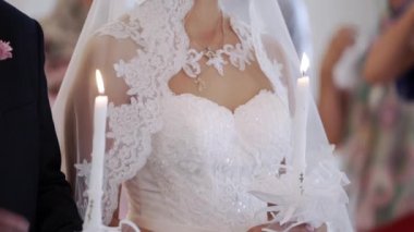 Gelin ve damat töreninde kilisede mum tutan