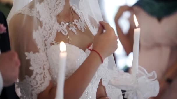 Наречений і наречений тримають свічки в церкві на церемонії — стокове відео